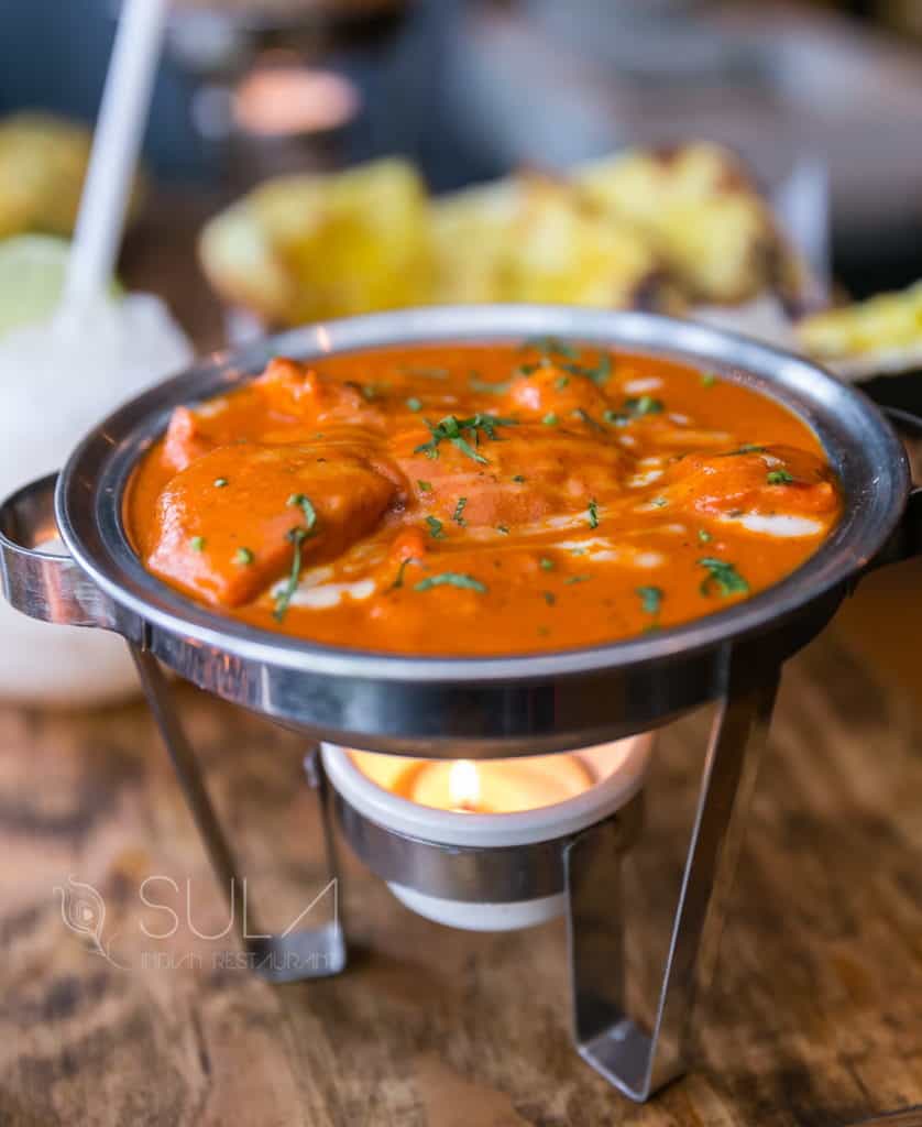 Butter chicken served with garlic naan at Sula on Commercial Drive