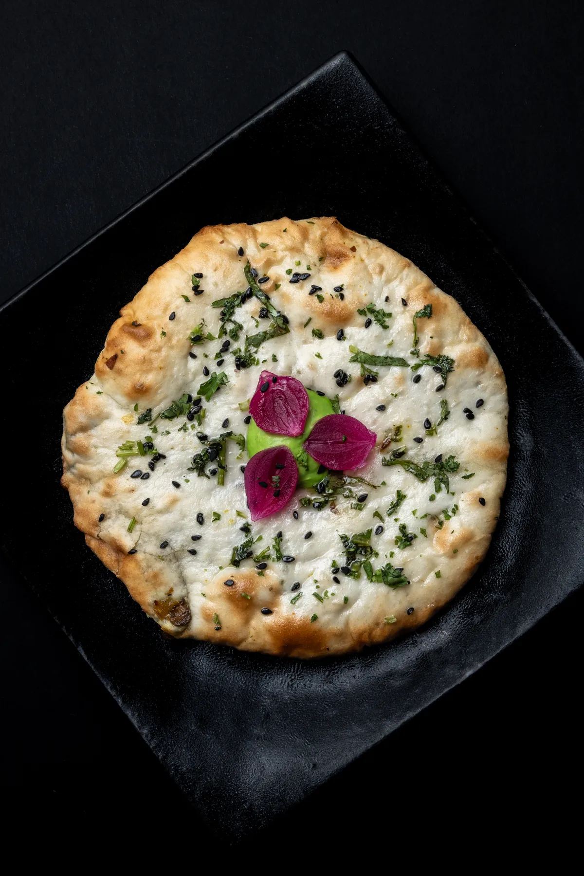 Butter Bhuna Guchhi Mini Kulcha, the Jammu and Kashmir course, a morel-filled flatbread finished with herbs, nigella seeds and pickled onion.