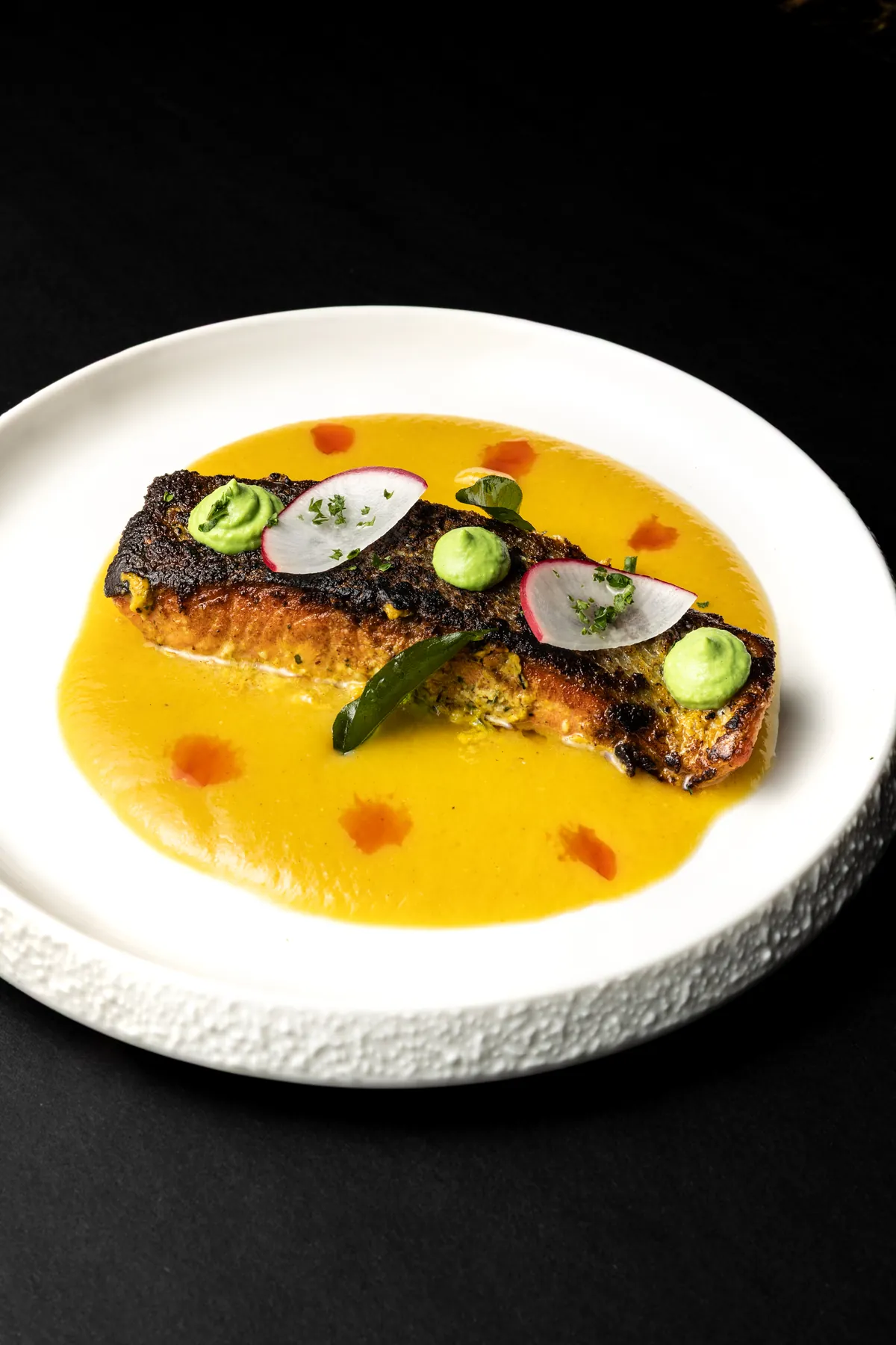 Golden Roots and Coastal Waters, the Kerala course, seared fish in a turmeric sauce with radish, curry leaf and herb puree.