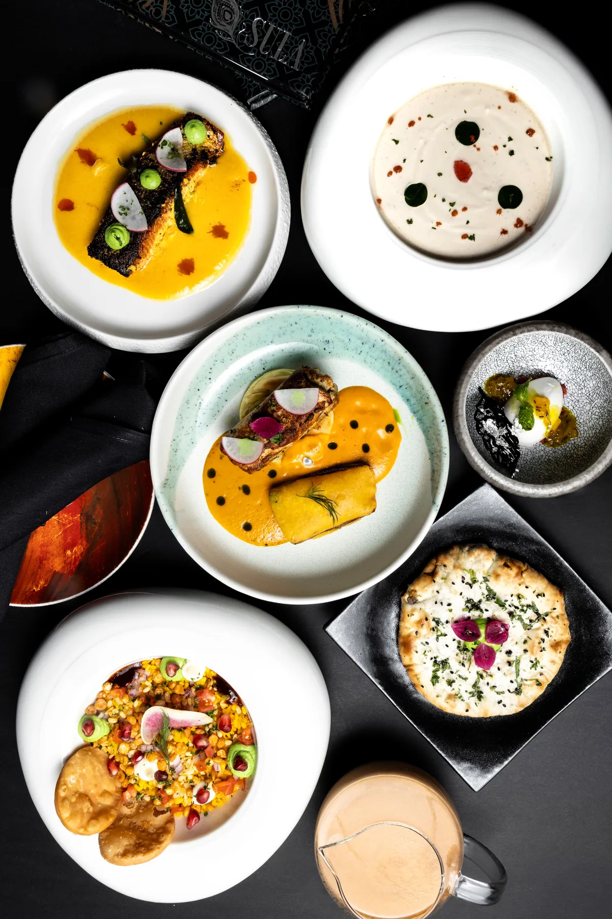 The seven-course Spice Route tasting menu at Sula Davie Street, plated across the table with the Sula menu card.